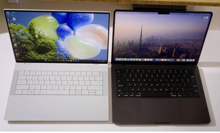 The Dell XPS 14 and MacBook Pro side by side on a white desk.