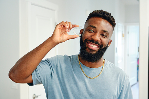 Young Man Holding Invisible Dental Aligners