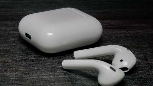 AirPods and case sitting on a table. 