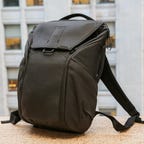 A black backpack sits on a building ledge.