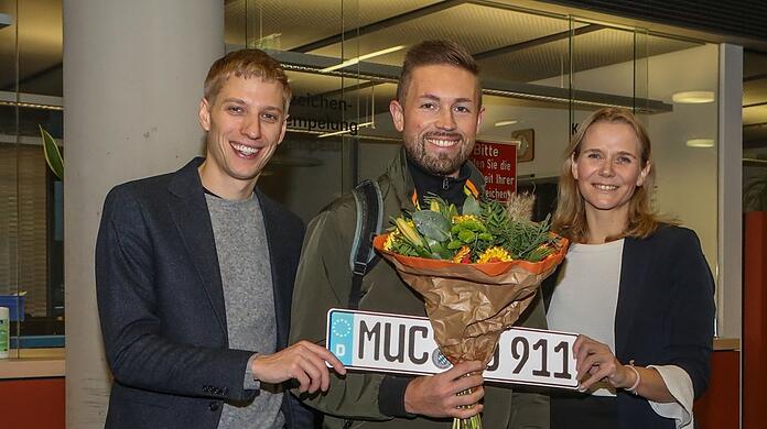 Bürgermeister Dominik Krause (Grüne), Rasmus Schneider mit dem ersten MUC-Schild der Stadt, und KVR-Chefin Hanna Sammüller-Gradl in der Zulassungsstelle.