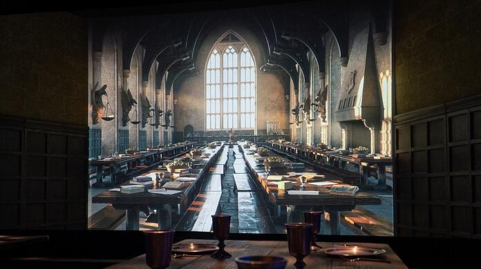 Im großen Speisesaal von Hogwarts kann man jetzt mitessen - in der Ausstellung geht der echte Holztisch in den virtuellen Raum über.