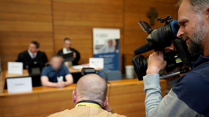 Medienvertreter filmen den Angeklagten (Hintergrund Mitte) im Landgericht Traunstein.