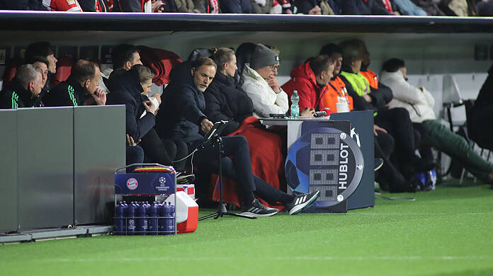 Thomas Tuchel auf der Bayern-Bank gegen Rom, den schmerzenden Fuß ausgestreckt.