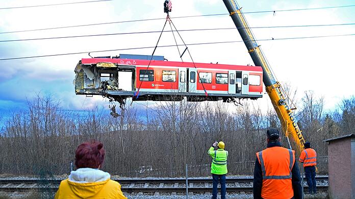 Mit einem Spezialkran heben Techniker den Triebwagen von einem der beiden verunglückten S-Bahn Züge von den Schienen.