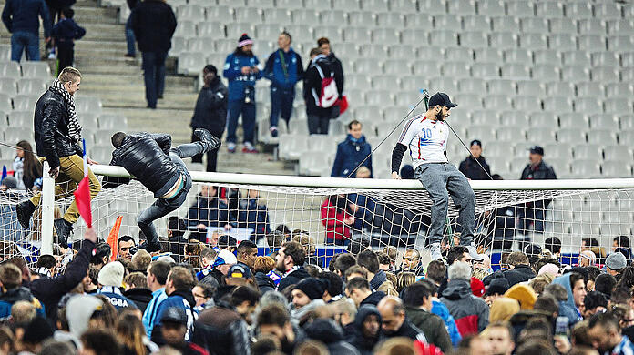 Vor neun Jahren harren Fußballfans aus Frankreich und Deutschland nach einem Testspiel der beiden Nationalmannschaften auf dem Rasen des Stade de France in Paris aus. Außerhalb der Arena verüben Terroristen ein Massaker. Aktuell ist die Bedrohungslage wieder hoch.