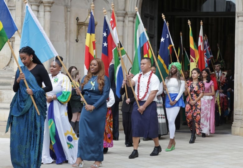 People carrying flags leave a large church.