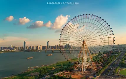 Blick auf das Riesenrad Star of Nanchang in China mit der Skyline der City im Hintergrund