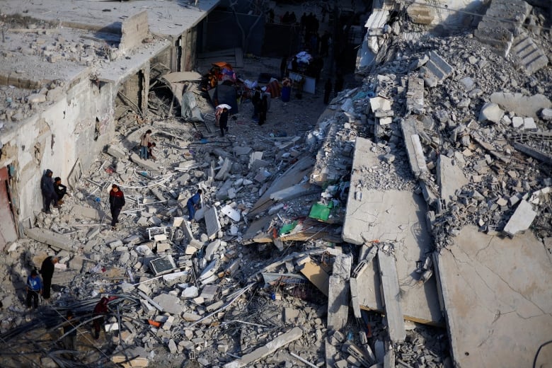 Palestinians inspect the site of an Israeli airstrike. 