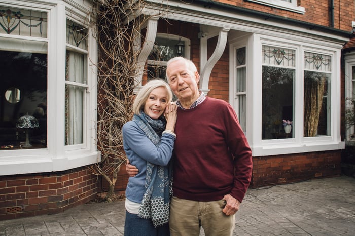 Two people standing in front of a house.