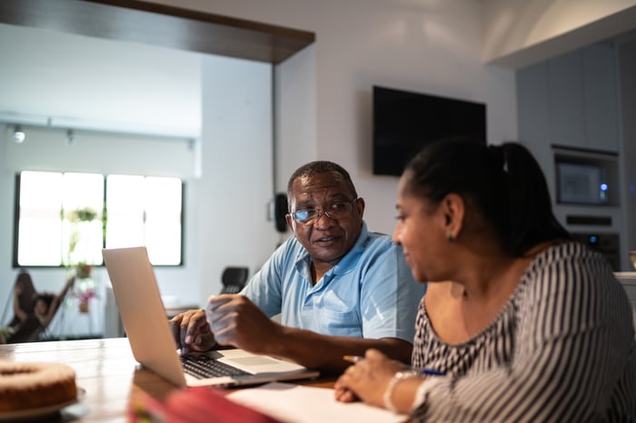 Two adults looking at financial paperwork. 