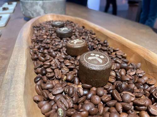 a row of k round compostable pods in a bed of coffee beans