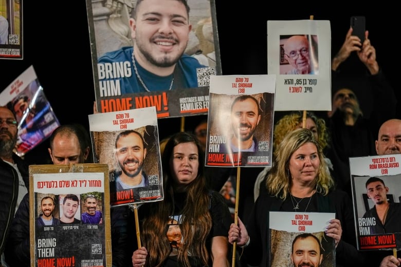 Families and supporters of Israeli hostages held by Hamas in Gaza hold their photos and shout slogans during a rally calling for their release, in Tel Aviv, Israel, Saturday, Dec. 30, 2023. More than 100 Israeli hostages are held in Gaza after being abducted in a Hamas cross-border attack on Oct. 7