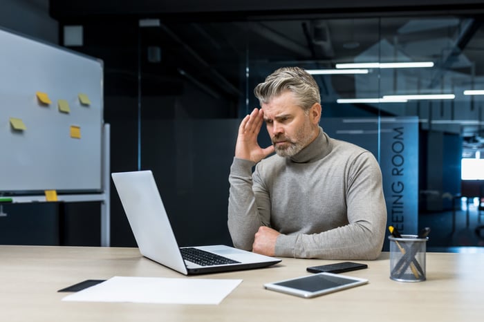 A person looks at a laptop in an office.