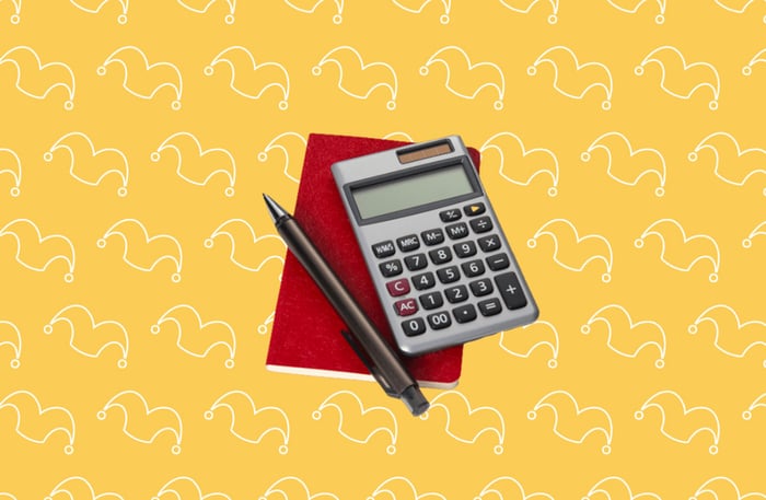 A calculator, pad, and pen against a yellow background