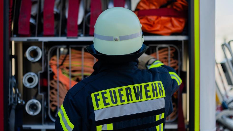 Brand: Ein Feuerwehrmann holt Equipment aus einem Einsatzfahrzeug an der Feuerwache der Feuerwehr.