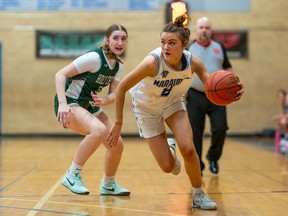 Walter Murray Collegiate Marauders guard Ryan Deutscher dribbles the basketball past Holy Cross Crusaders guard Sloane Holt Mellor during city high school senior girls' basketball finals in Saskatoon, Sask., on Friday, March 15, 2024.