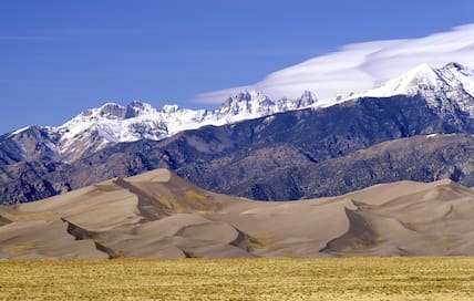 Blick auf die Sanddünen vor der Berglandschaft der Rocky Mountains im Great Sand Dunes National Park in den USA