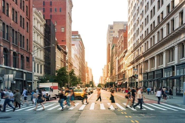 A busy intersection of cars and people in New York City.