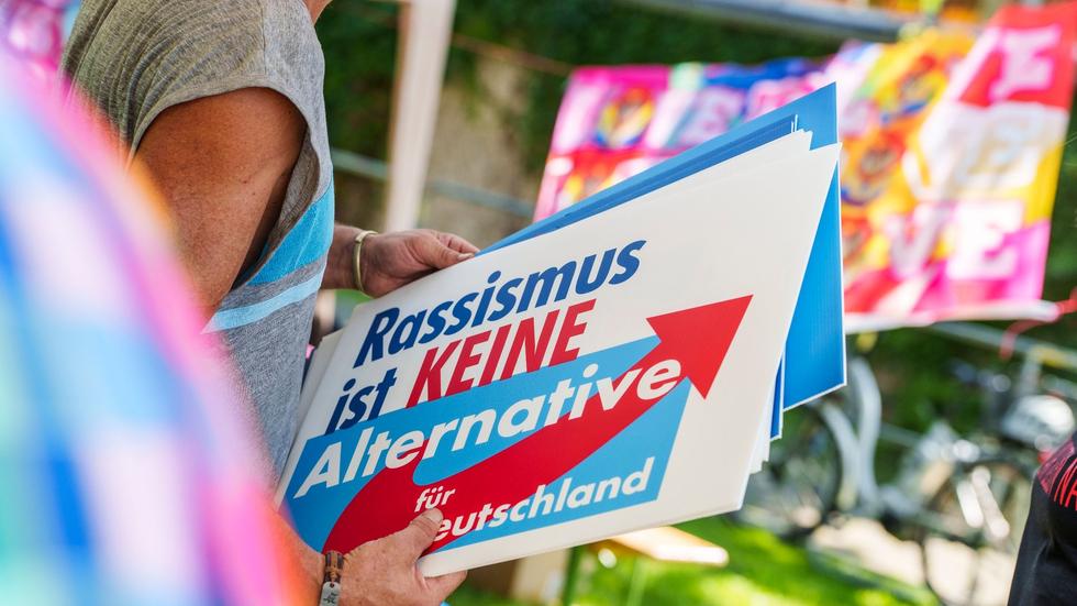 Wahlkampfveranstaltung: Eine Frau hält bei einer Gegendemo ein Schild mit der Aufschrift «Rassismus ist keine Alternative» in den Händen.