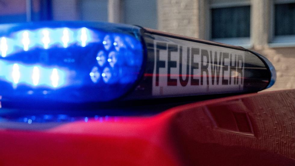 Löscharbeiten: Ein Fahrzeug der Feuerwehr steht mit eingeschaltetem Blaulicht an einem Einsatzort.