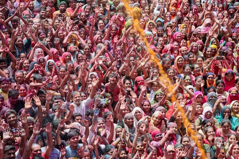 A crowd is sprayed with coloured water.