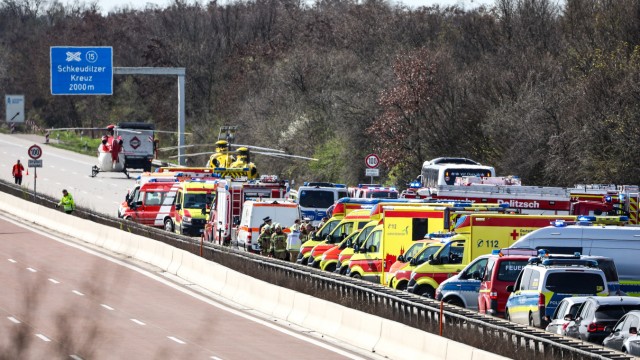 Sachsen: Einsatzfahrzeuge und Rettungshubschrauber stehen auf der A 9 an der Unfallstelle.