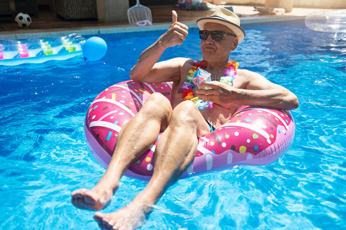 Person in a round inner tube in a swimming pool flashing a thumbs-up.