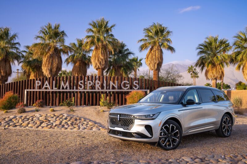 A silver Lincoln Nautilus next to a sign that says Palm Springs