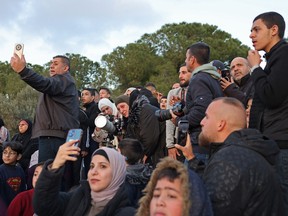 A woman uses a telescope to look for the moon to mark the start of Islamic holy fasting month of Ramadan near the Dome of the Rock at the compound of the Al-Aqsa mosque in the Old City of Jerusalem on Sunday, March 10, 2024.