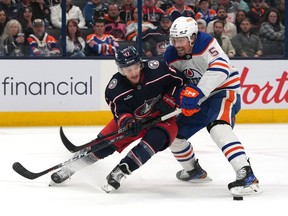 Cody Ceci #5 of the Edmonton Oilers and Justin Danforth #17 of the Columbus Blue Jackets battle for the puck during the second period at Nationwide Arena on Thursday, March 7, 2024, in Columbus, Ohio.