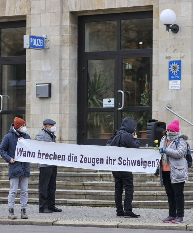 Menschen mit Transparent vor einer Polizeiwache