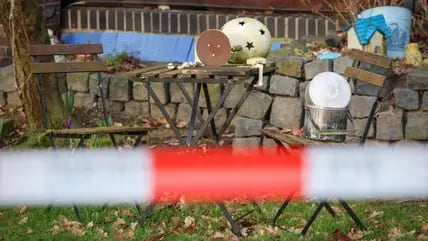 Gartendekoration steht hinter Absperrband der Polizei vor einem Haus in Westervesede in der Gemeinde Scheeßel. Ein Bundeswehrsoldat soll im Kreis Rotenburg vier Menschen erschossen haben.