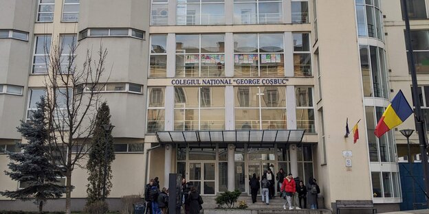 Ein paar Menschen sind vor dem Gebäude der rumänischen Schule George Coşbuc in der Stadt Cluj-Napoca zu sehen