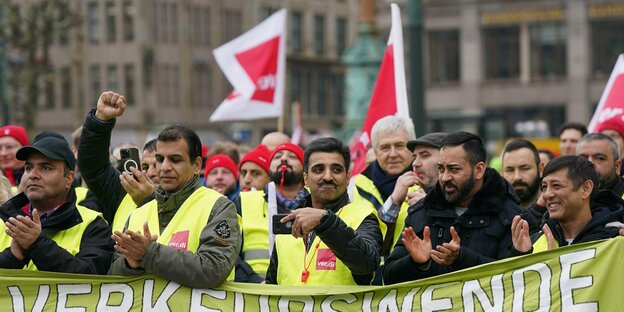 Demonstranten stehen hinter einem Banner mit der Aufschrift 