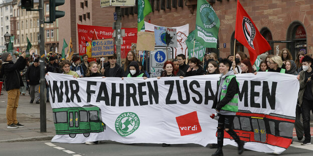 Demonstration mit Fahnen und Transparent.