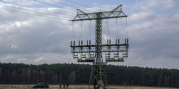 Ein Strommast auf einem Feld