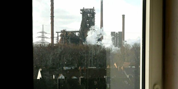 Blick aus dem Fenster auf die qualmenden Schornsteine von Thyssen Krupp in Duisburg Maxloh