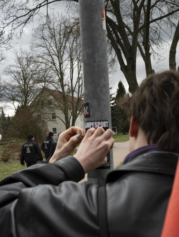 Demonstranten entfernen an einem Masten Nazisticker