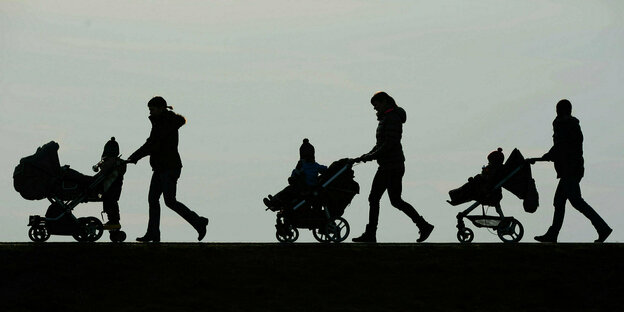 Drei Mütter schieben ihre Kinderwagen