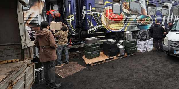 MÄnner laden Kartons aus einem Zug aus