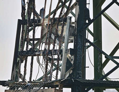 Ein Strommast steht mit Brandspuren auf einem Feld nahe der Tesla-Autofabrik. In der Tesla-Autofabrik in Grünheide steht die Produktion wegen eines Stromausfalls nach einem Brandanschlag auf den Hochspannungsmast still. Die Polizei geht nach einem Stromausfall am Dienstagmorgen mit Folgen für die Tesla-Fabrik in Grünheide bei Berlin dem Verdacht der Brandstiftung nach. Ein Bekennerschreiben ist aufgetaucht.