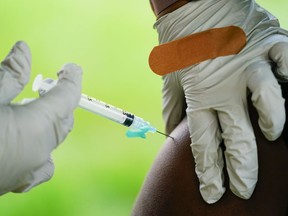 In a sea of misinformation about COVID-19 vaccines, a debunked claim that inoculation against the disease can cause cancer remains especially dangerous for vulnerable patients seeking answers about their diagnosis, experts say. A health worker administers a dose of COVID-19 vaccine during a vaccination clinic in Reading, Pa. &ampnbsp;On Friday, Oct. 7, 2022.