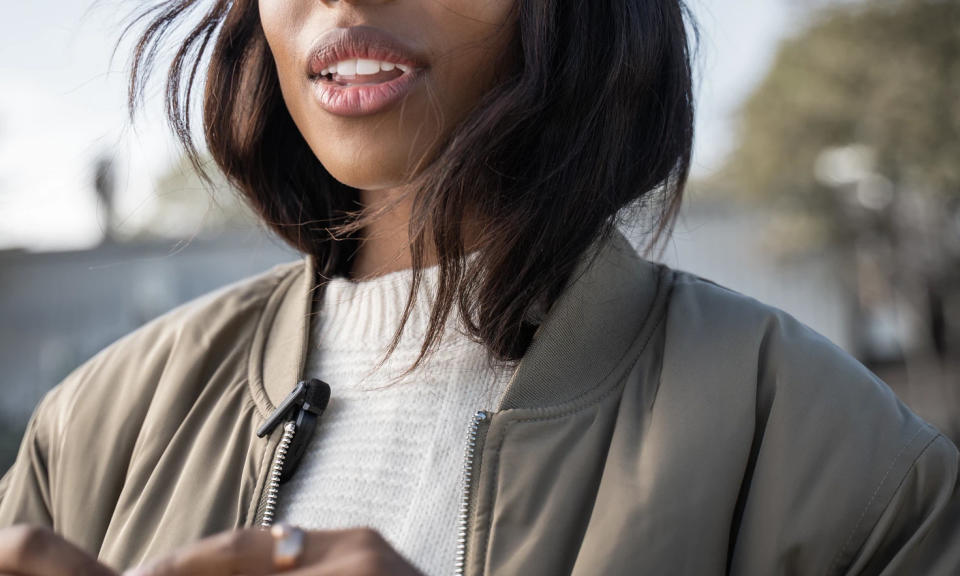 Product lifestyle shot of a person with the Shure MoveMic clipped to their light jacket.