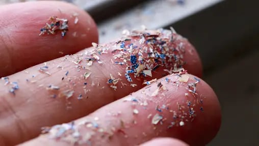 Close up side shot of microplastics lay on people hand.Concept of water pollution and global warming. Climate change idea.