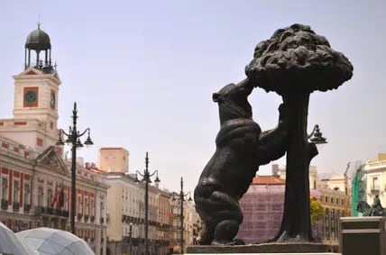 Der Bär und der Erdbeerbaum sind Symbole der Stadt. Links im Hintergrund das prächtige Königliche Postamt – la Real Casa de Correos.