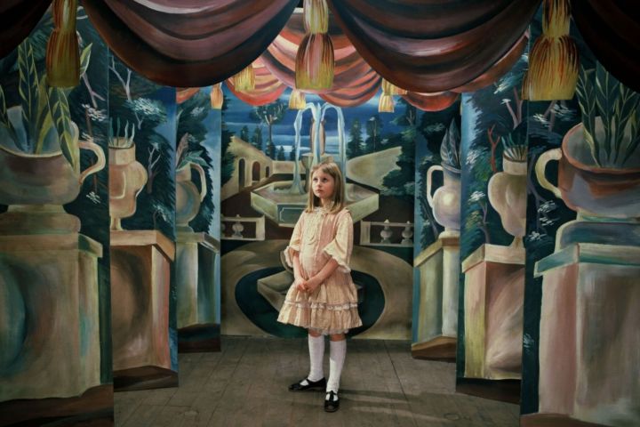 A girl stands in the middle of a room in Alice (1988).