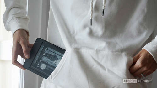 A user pulls an Amazon Kindle 2022 out of their sweatshirt pocket.