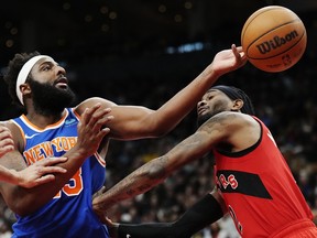 New York Knicks' Mitchell Robinson (left) battles for a rebound with Raptors forward Jalen McDaniels' during the second half in Toronto on Wednesday, March 27, 2024.