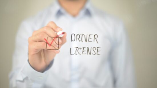 Man writing "Driver's License" with a check box on a clear screen